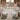 Elegant banquet table setup with floor-length ivory tablecloths, chair covers and napkins in a wedding reception hall